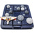 Asteroid Escape game in play. The gameboard is a dark navy blue with square navy blue playing pieces on top. Each playing piece stars and moon shaped pieces in shades of gray. One square has a space ship in silver and orange. 