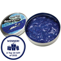 Crazy Aaron’s Angry Putty, Stress Ball. The large round tin has glittery dark blue putty swirled inside. The putty is reflecting the light and you can see the small, rectangular and circle shaped glitter inside the putty, shining in silver. The lid to the left shows a drawn stressed face with sweat beads splashing from the face on top of a band of putty. There is a Timberdoodle, Top gift of 2022, award badge over the image in the bottom-left.