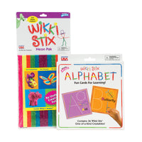 The Wikki Stix Alphabet Deluxe set. To the left is the Neon Pack that has many neon-colored wax-covered strings. There are completed projects using the wax sticks on the packaging. The Alphabet set to the right is a white box with a picture of 2 of the Alphabet boards in the middle. The A and B boards have uppercase and lowercase letters with an ant and a butterfly on them. There is a hand coming out from the bottom-right corner putting a wax stick on the lower-case b.